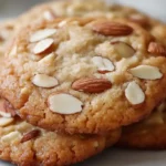 Freshly baked copycat Crumbl cookies recipe arranged on a baking tray with melting chocolate chips, golden edges, and rustic kitchen details