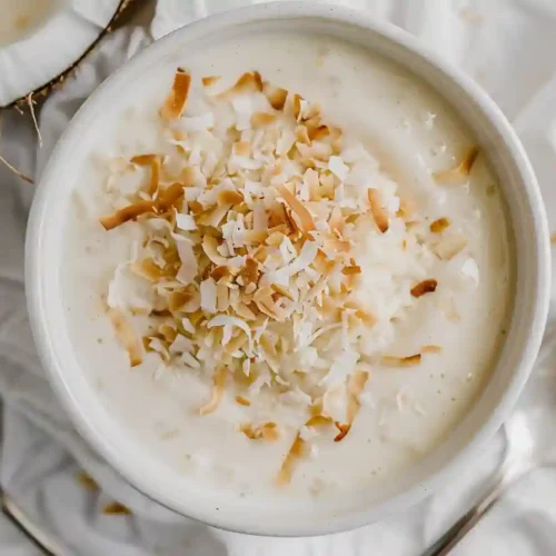Easy Rice Pudding Recipe: Creamy, Old Fashioned & Homemade Dessert 4 Creamy homemade rice pudding recipe served warm in a rustic bowl, garnished with cinnamon and raisins.
