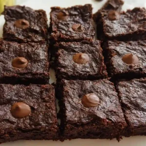 Rich and gooey avocado brownies stacked on a ceramic plate