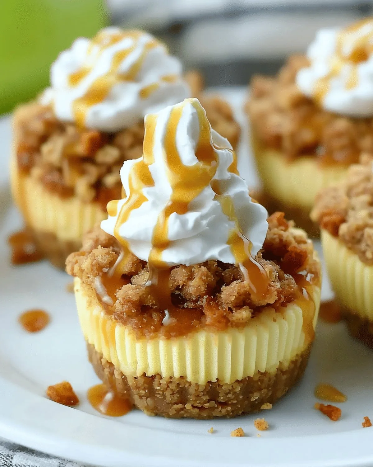 Delicious Apple Crisp Mini Cheesecakes topped with crunchy apple and cinnamon