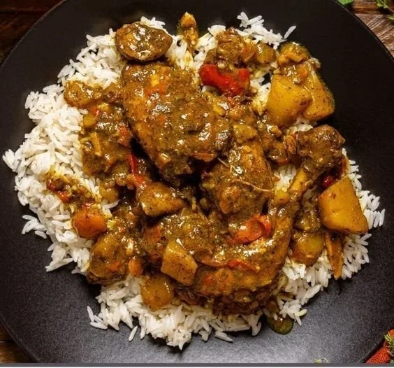 Bowl of authentic Jamaican Curry Chicken with vibrant spices and herbs