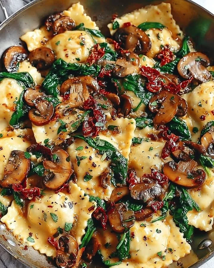 Cheesy ravioli filled with spinach, mushrooms, and sun-dried tomatoes served on a plate.