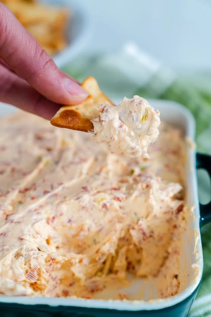 Delicious crowd-pleasing dip served in a bowl with fresh vegetables and chips.