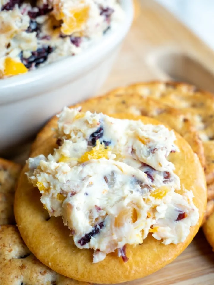 Festive zesty dip served in a bowl with colorful veggies for dipping.
