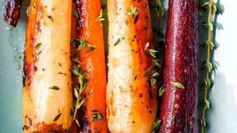 Dish of honey roasted colorful carrots garnished with herbs