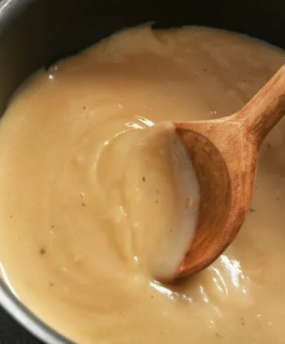 Delicious Mom's Turkey Gravy served over a holiday turkey dinner
