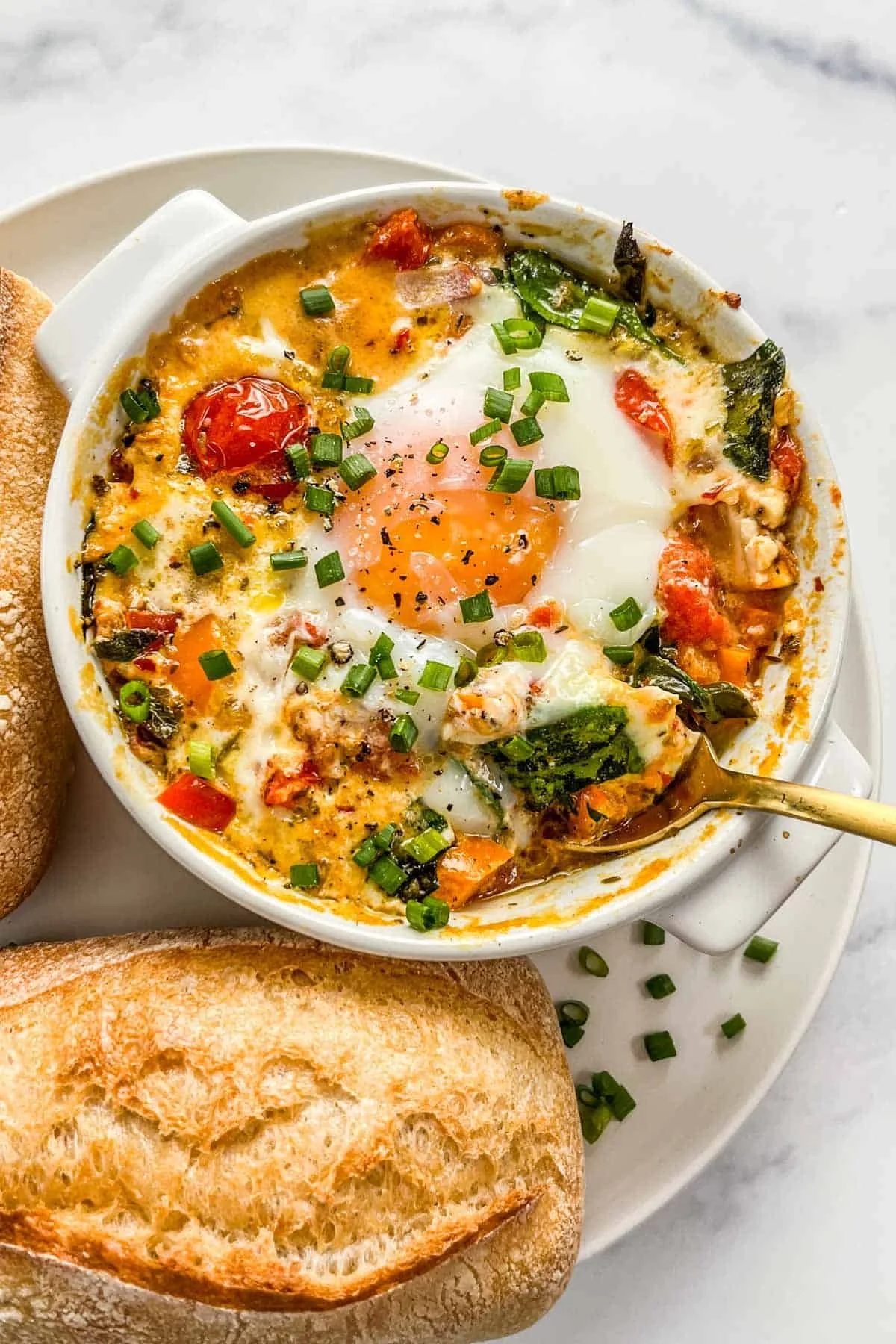 Delicious baked feta eggs served in a rustic dish, garnished with herbs.