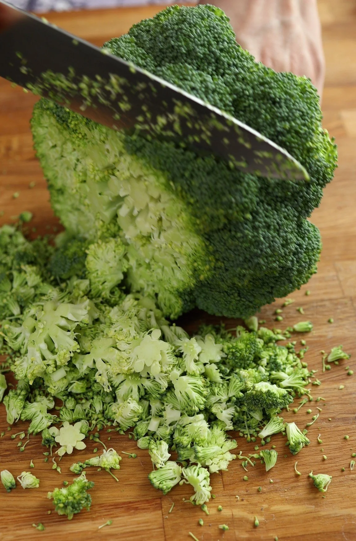 Fresh broccoli with vibrant green florets and stems on a wooden cutting board