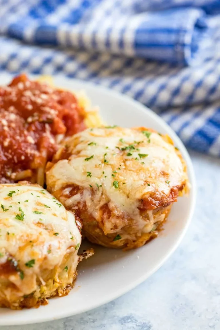 Chicken Parm Mini Meatloaf Muffins baked on a tray with herbs and cheese.