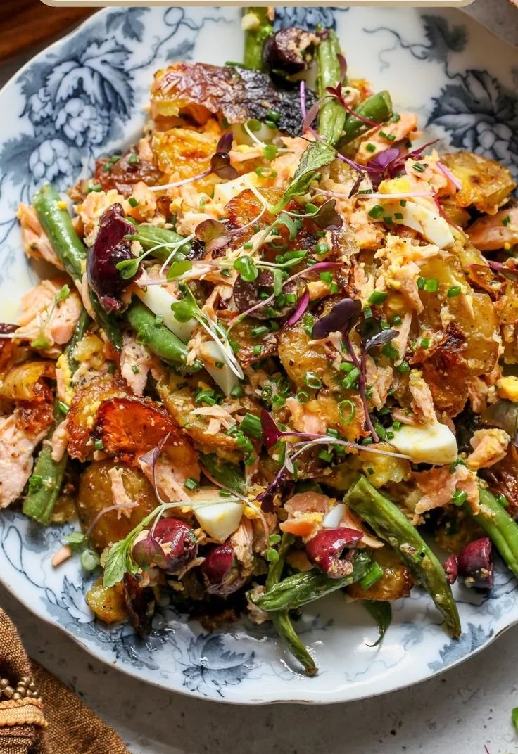 Crispy Smashed Salmon Niçoise Salad with flavorful ingredients on a plate.