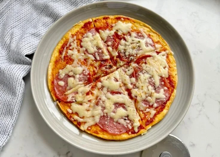 Pizza Eggs topped with cheese and herbs served on a plate