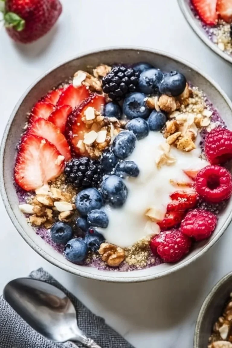 Colorful berry quinoa breakfast bowls topped with fresh fruits and nuts.