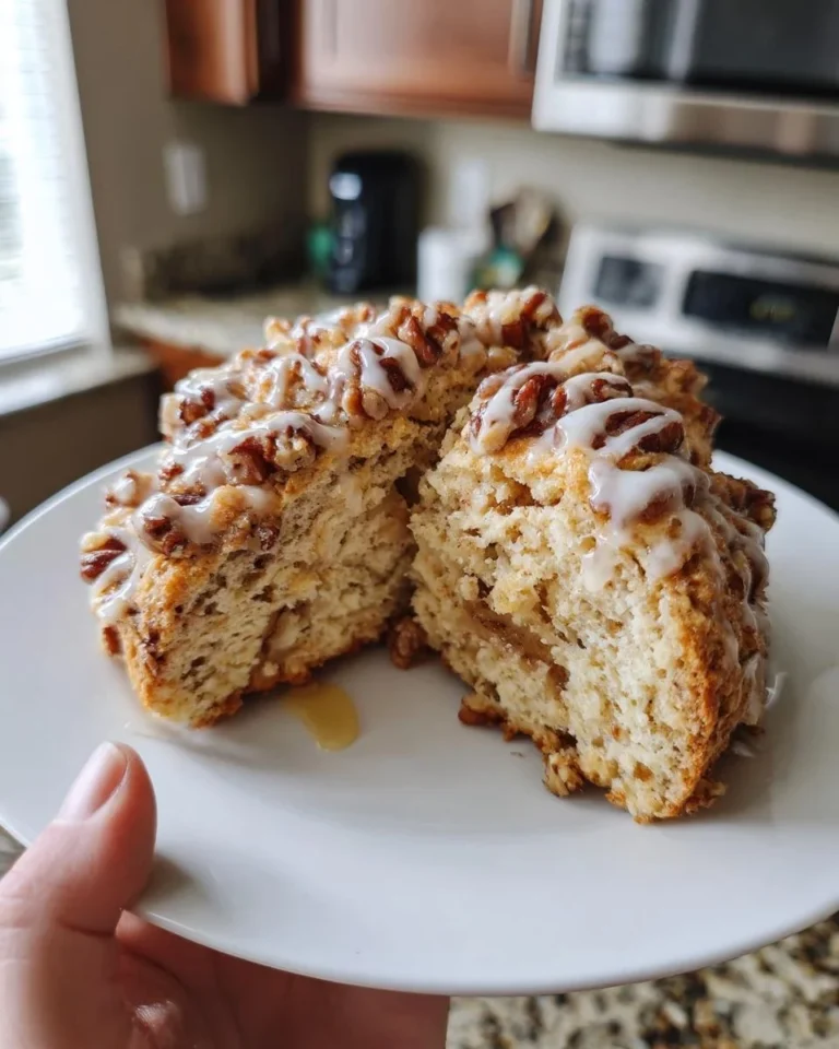 Freshly baked maple pecan scones on a plate with maple syrup drizzle
