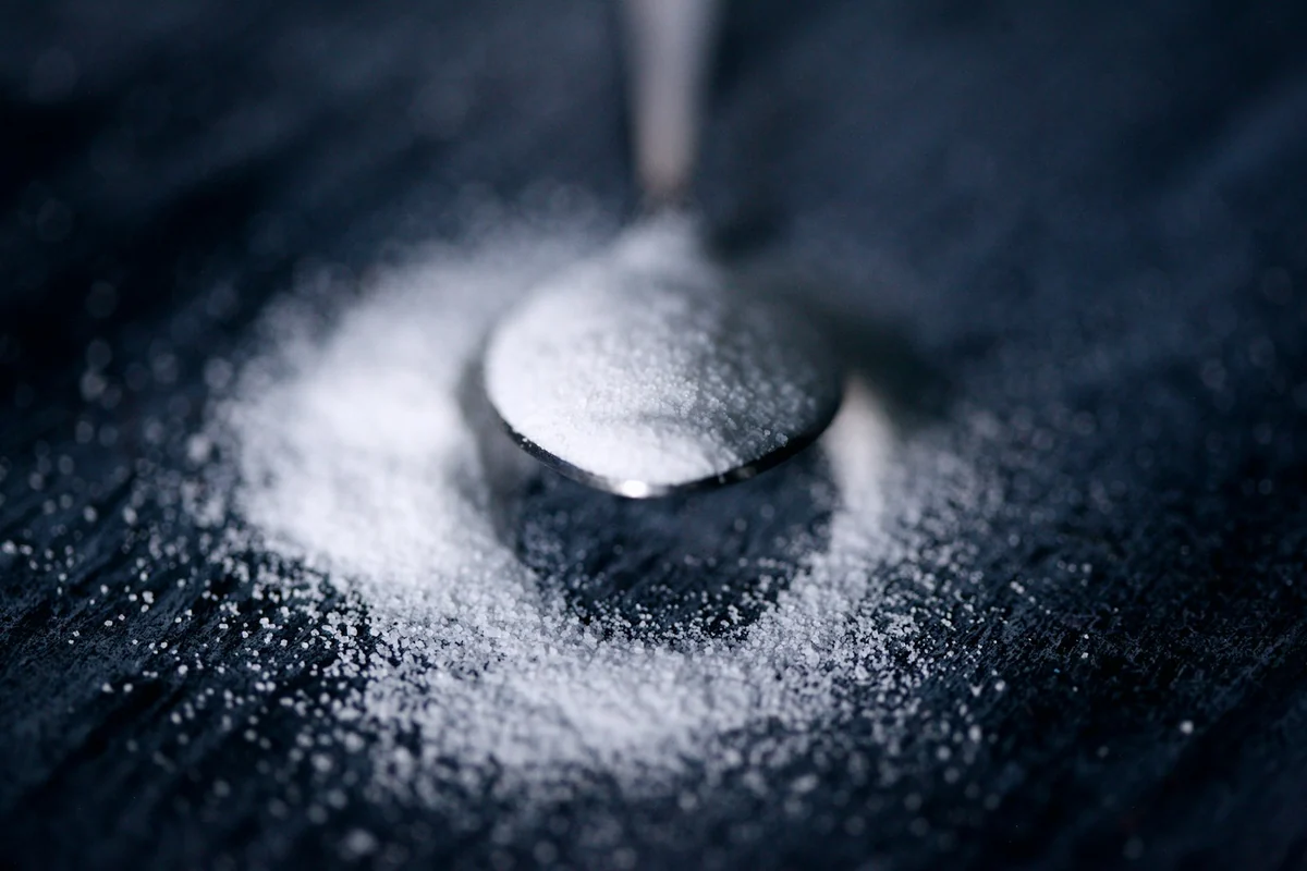 Half a teaspoon of baking soda on a metal spoon, the amount used in the baking soda weight loss drink